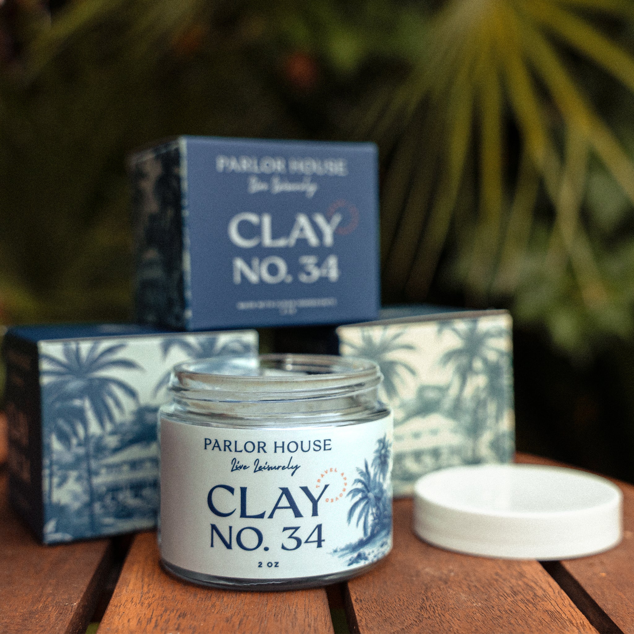 Clay No. 34 matte finish hair clay for men — open jar in front of stacked signature Parlor House boxes.